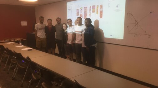 students posing for a picture in front of a whiteboard